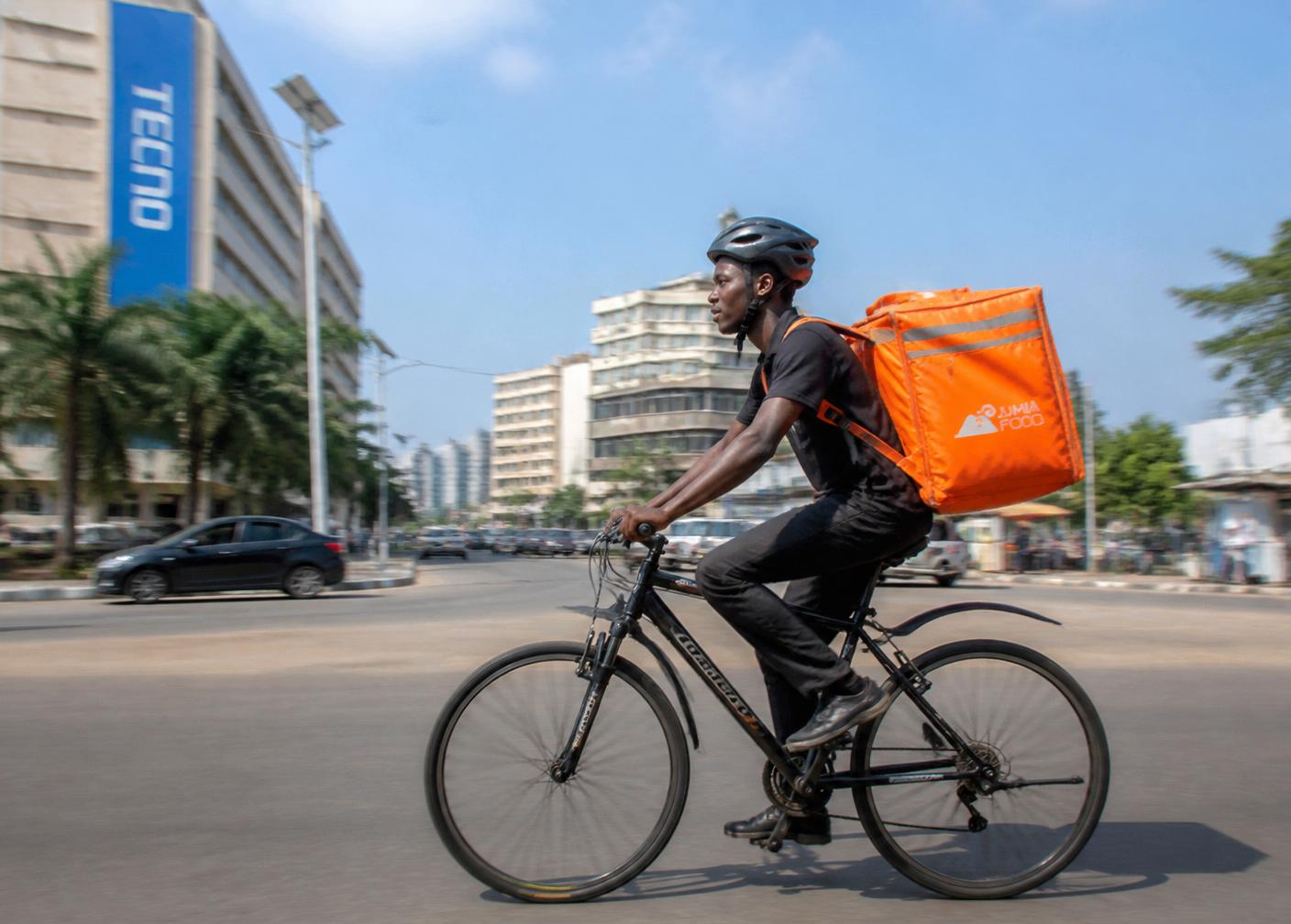 A bicycle courier with a food delivery backpack
